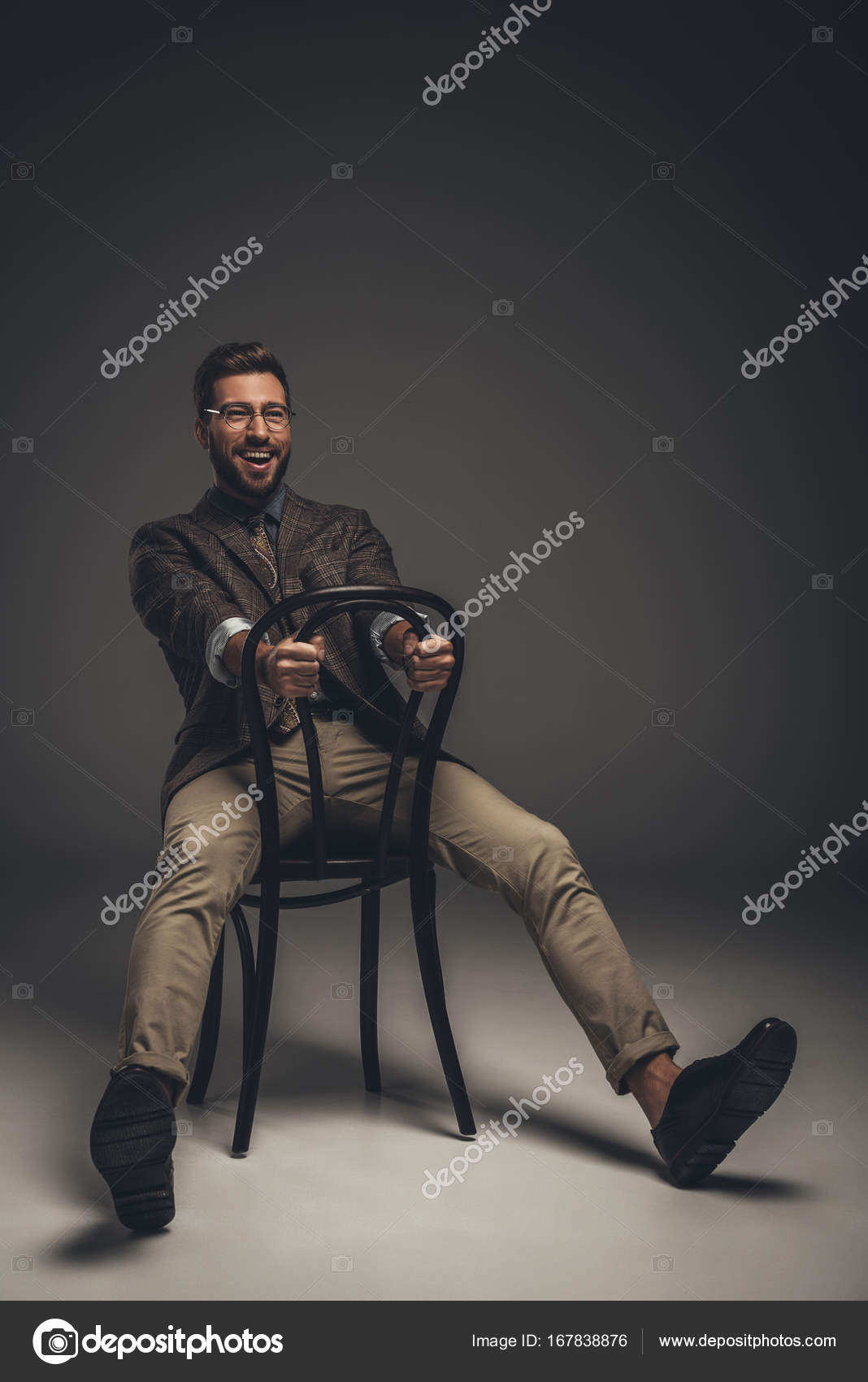 Man in suit sitting on chair backwards Stock Photo by ©AllaSerebrina
