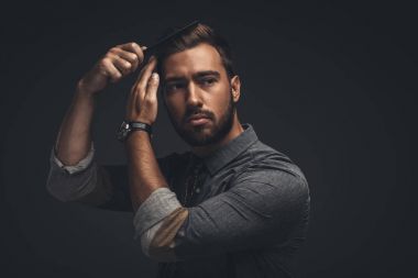 Handsome man grooming hair