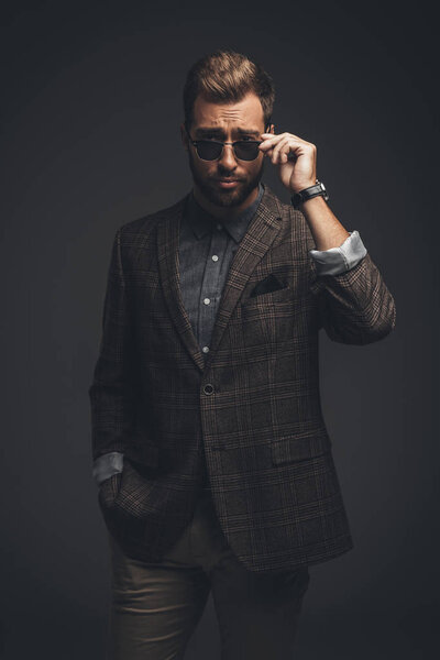 Man in suit looking over sunglasses