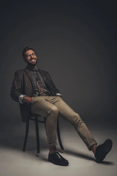 Laughing man in suit sitting on chair — Stock Photo, Image