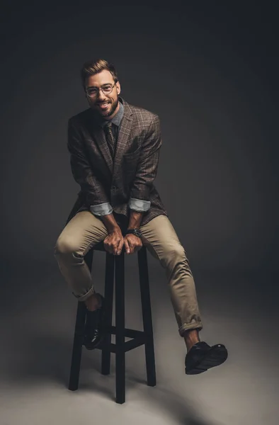 Homme en costume assis sur tabouret de bar — Photo