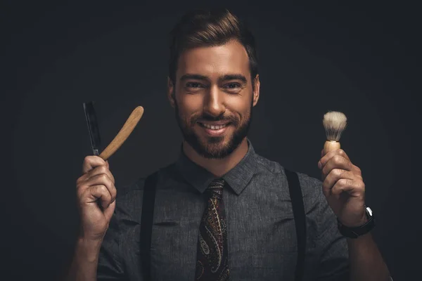 Hombre sosteniendo maquinilla de afeitar y cepillo — Foto de Stock