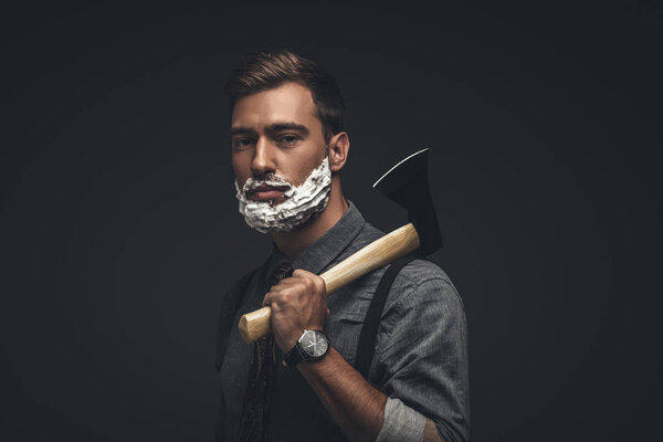 Man in shaving cream holding axe