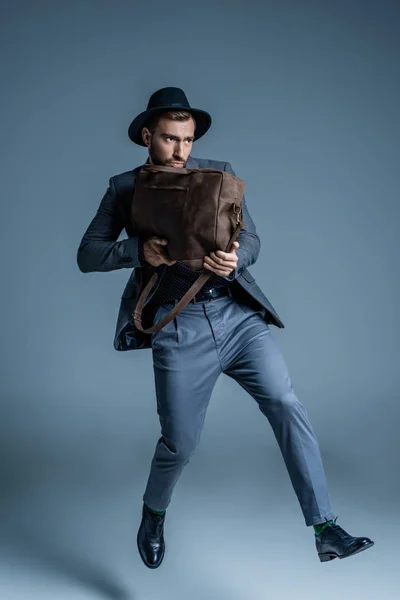 Man in suit holding leather bag — Stock Photo, Image