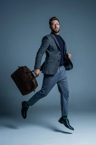 Homem de terno andando com saco de couro — Fotografia de Stock