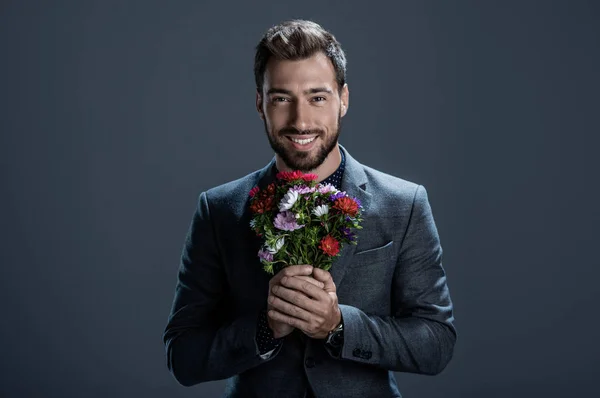 Schöner Mann mit Blumenstrauß — Stockfoto