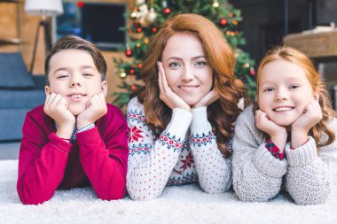 Anne ve çocuklar yere Noel'de döşeme