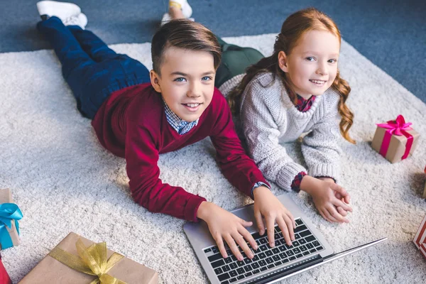 Брат и сестра используют ноутбук вместе — стоковое фото