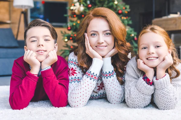 Mother and kids laying on floor on christmas — Stock Photo, Image