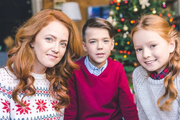 Mutter und Kinder im weihnachtlich dekorierten Zimmer — kostenloses Stockfoto