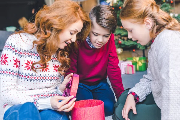 Mutter und Kinder öffnen Weihnachtsgeschenk — Stockfoto