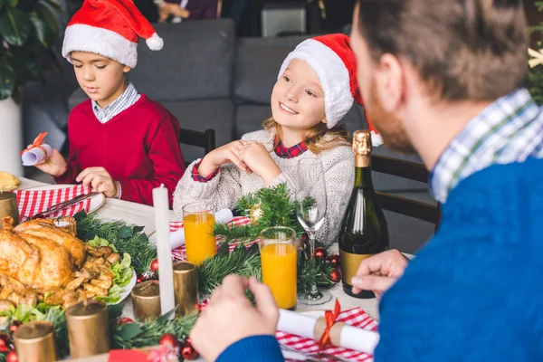 Father sitting at christmas table with kids — Free Stock Photo