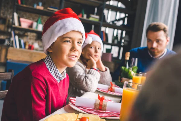 Dzieci siedząc przy stole christmas z ojcem — Darmowe zdjęcie stockowe