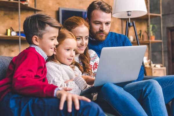 family looking at laptop
