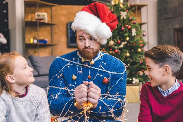 Kids and father tied up with garland — Stock Photo, Image