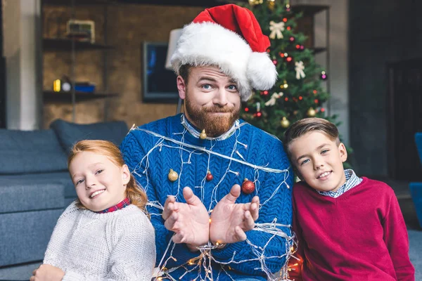 Kids and father tied up with garland — Stock Photo, Image