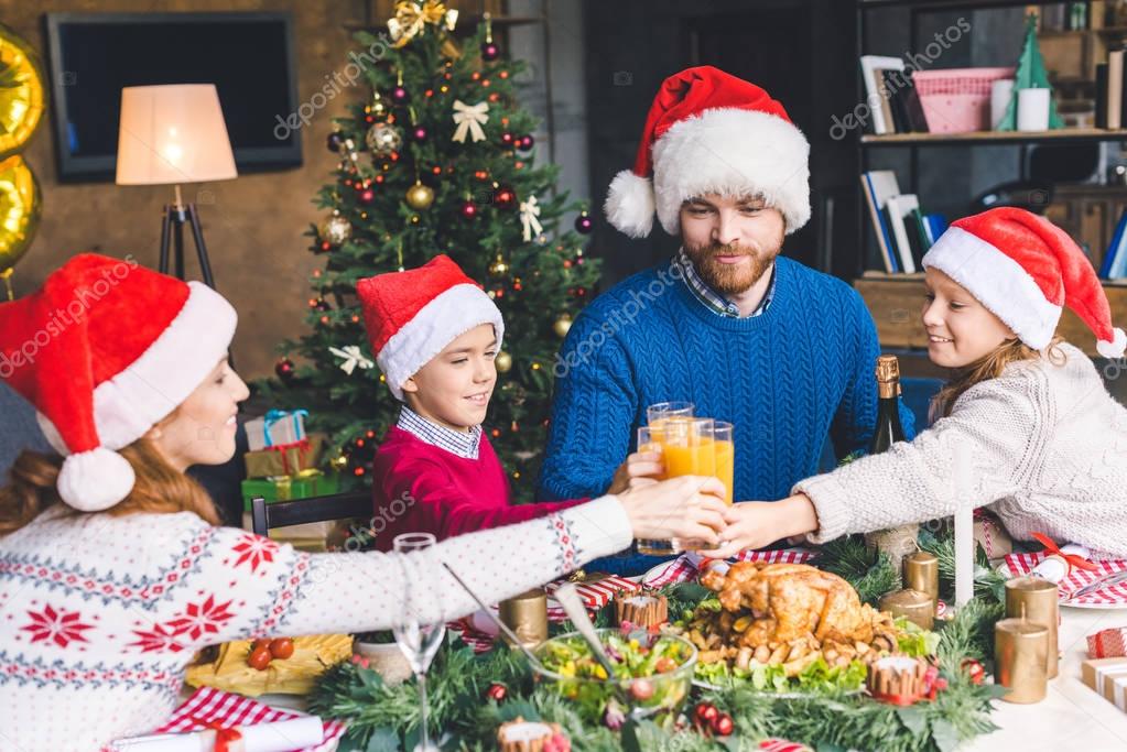 family clinking glasses on christmas dinner