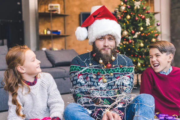 Kids and father tied up with garland — Stock Photo, Image