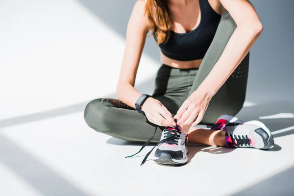 Sportswoman tying shoelaces — Stock Photo, Image