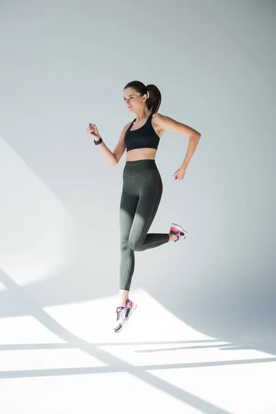 Прыгающая девушка в спортивной одежде — стоковое фото