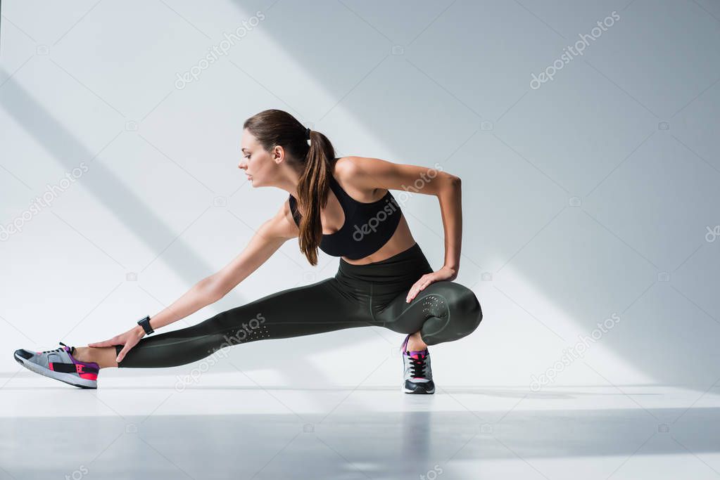 sporty woman stretching legs