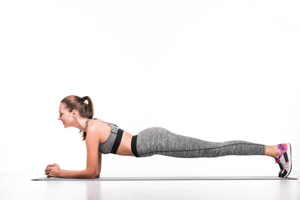 sportswoman exercising on yoga mat