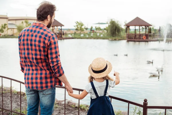 Family looking at pond in park — Free Stock Photo