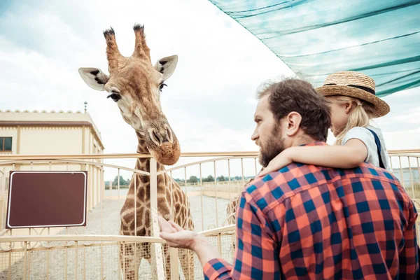 Familie schaut Giraffe im Zoo an — Stockfoto