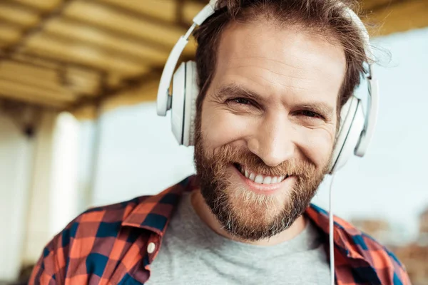 Homem sorridente em fones de ouvido — Fotografia de Stock