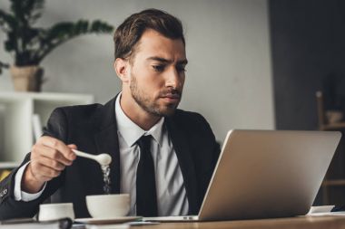 Kahve için şeker ekleyerek işadamı