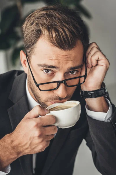 Overworked businessman drinking coffee — Free Stock Photo