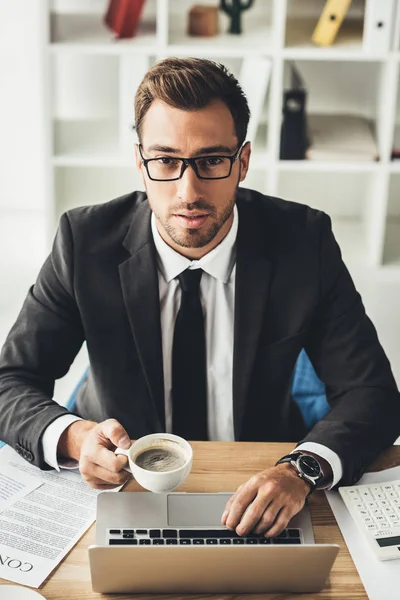 Businessman drinking coffee while working — Stock Photo, Image