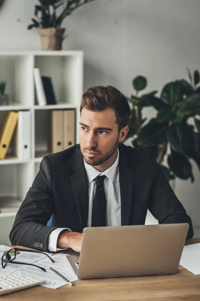 Thoughtful businessman with laptop — Stock Photo, Image