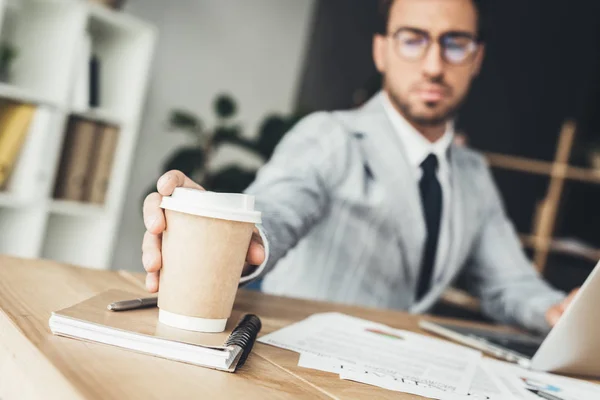 Businessman taking disposable cup of coffee — Stock Photo, Image