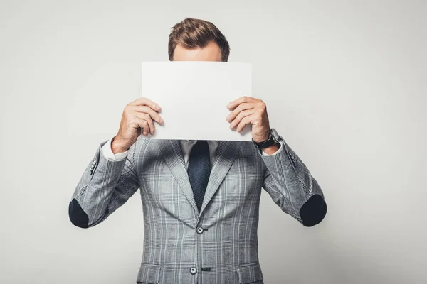 Hombre de negocios cubriendo la cara con papel — Foto de Stock