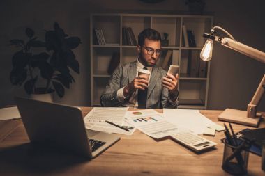 İşadamı smartphone kullanarak kahve ile
