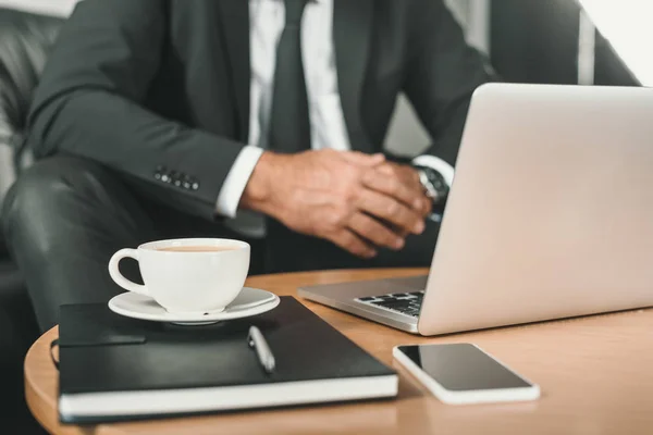 Бизнесмен с ноутбуком и кофе на столе — стоковое фото
