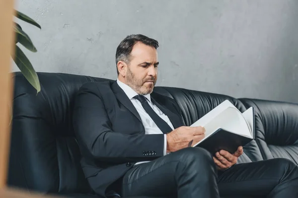 Empresario mirando el cuaderno — Foto de Stock