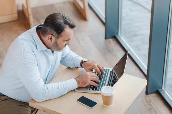 Uomo d'affari che lavora con il computer portatile in caffè — Foto Stock