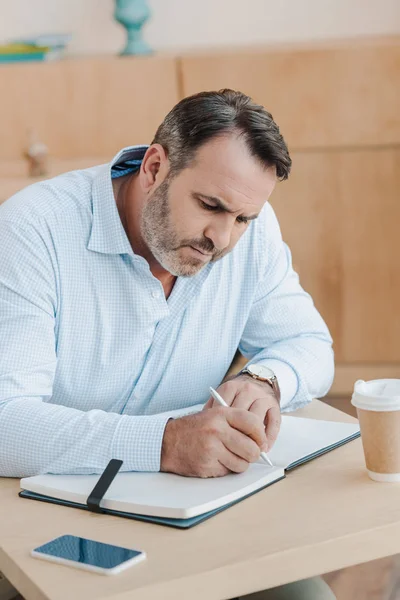 Empresário escrevendo em notebook — Fotografia de Stock