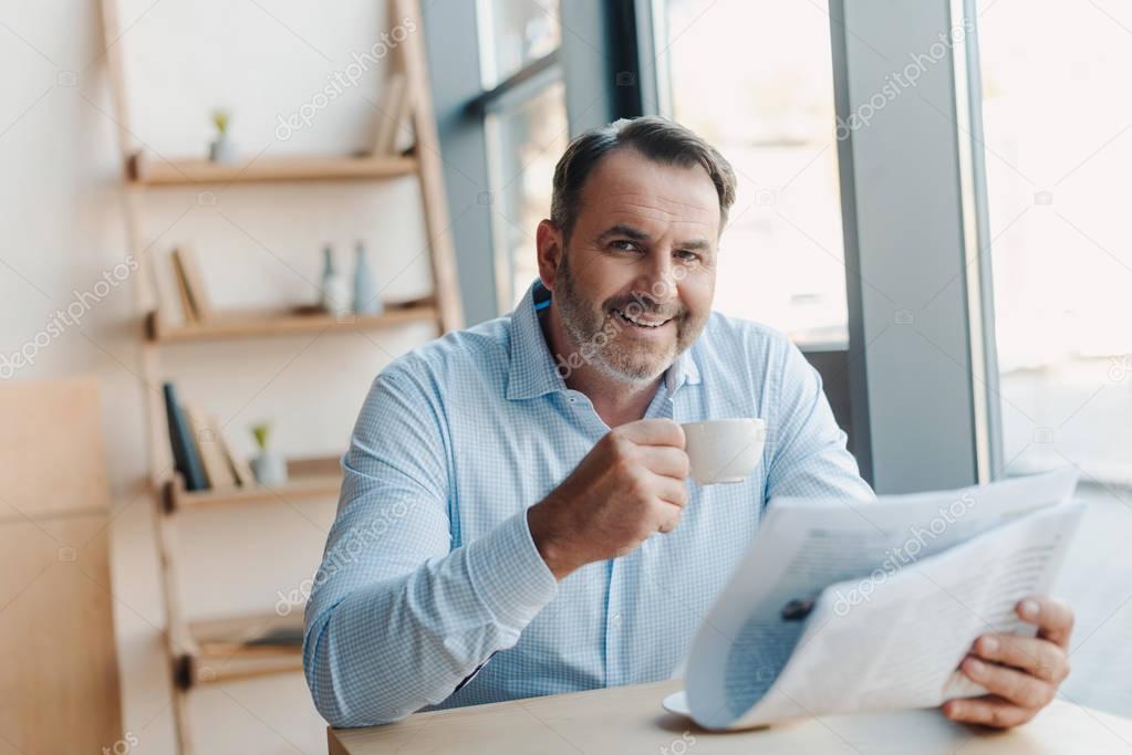 businessman drinking coffee with newspaper