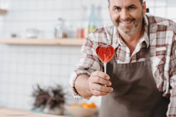 Bartender with lollypop in shape of heart — Stock Photo, Image