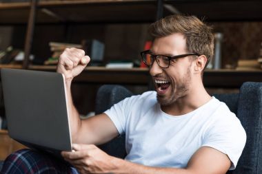 Cheering man using laptop