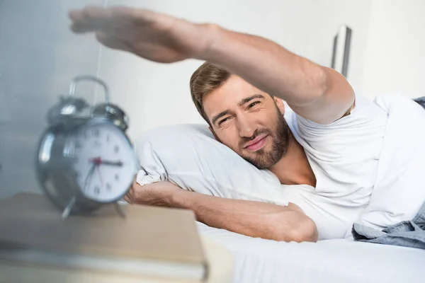 Man reaching for alarm clock — Stock Photo, Image