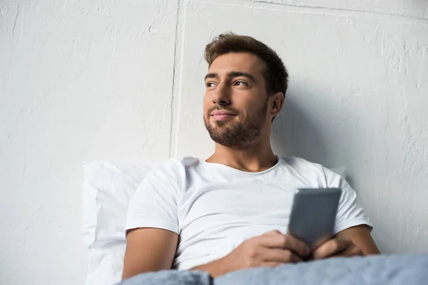 Man använder smartphone i sängen — Stockfoto