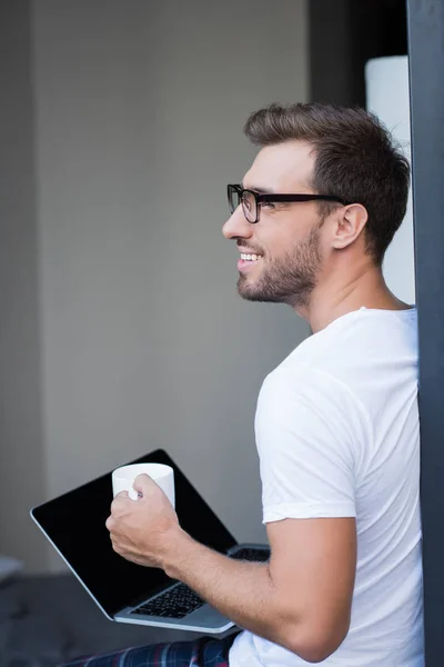 Hombre sosteniendo portátil y café — Foto de Stock