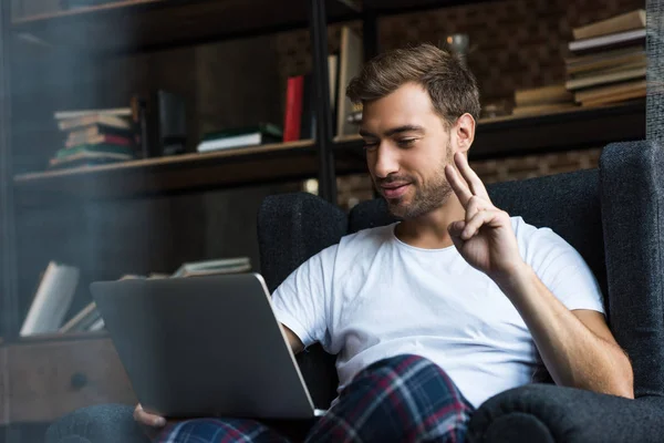 Uomo utilizzando il computer portatile e mostrando la pace — Foto Stock