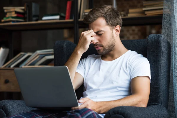 Zmęczony człowiek korzysta z laptopa — Zdjęcie stockowe