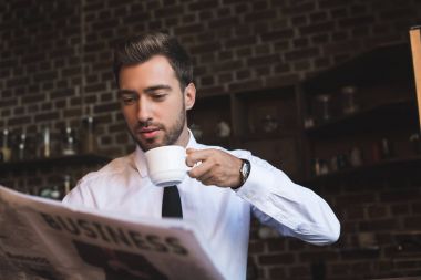 businessman drinking coffee and reading newspaper clipart