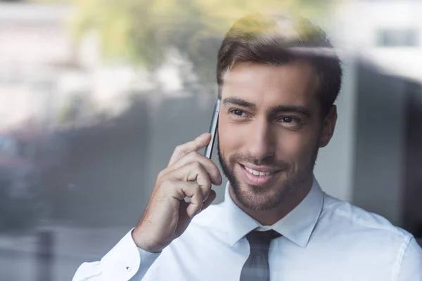 Biznesmen uśmiechający się mówić na smartphone — Darmowe zdjęcie stockowe